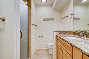 A bathroom with a shower, toilet, and sink.
