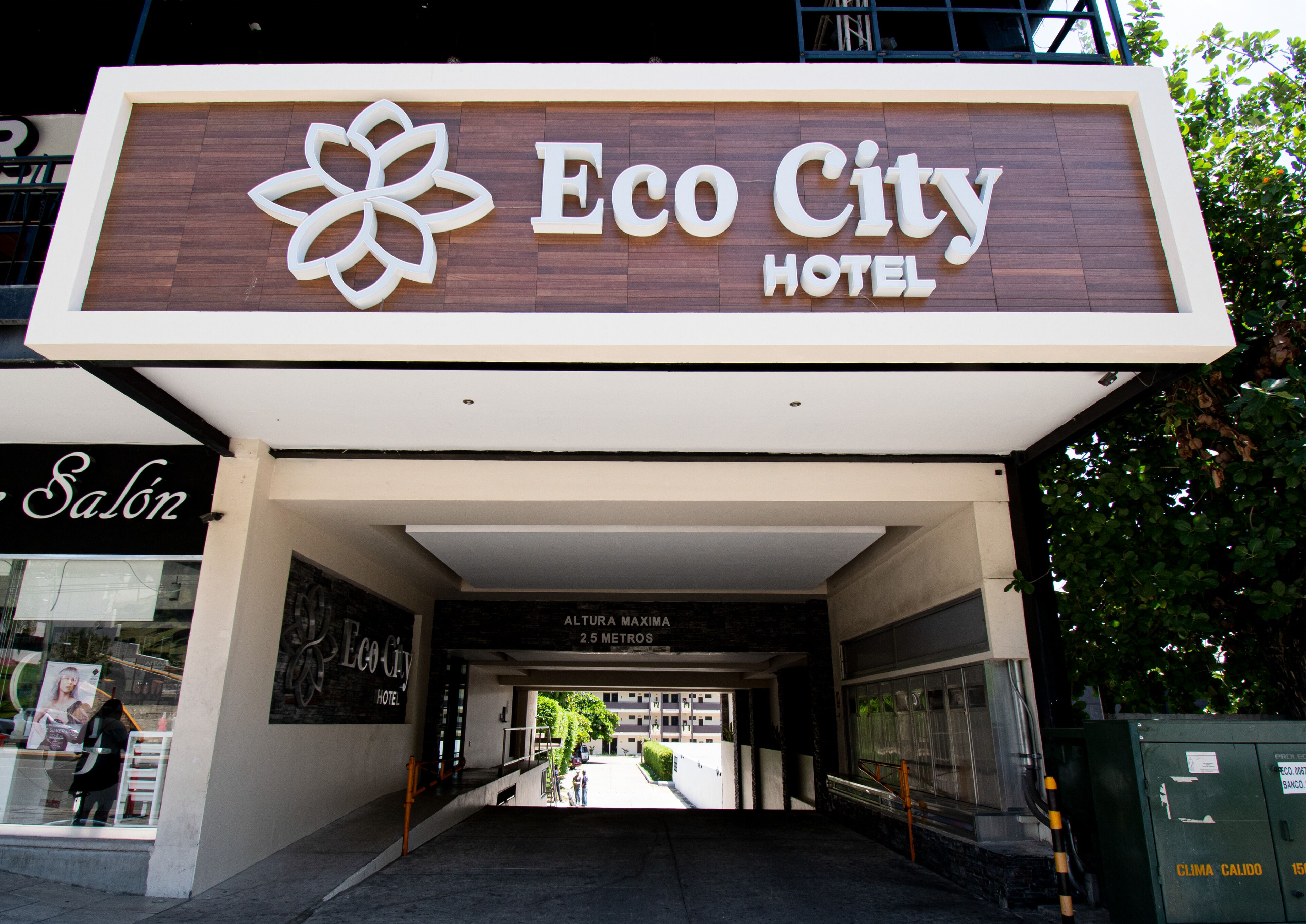 Der Eingang zum Eco City Hotel, mit einem Schild darüber und einem sichtbaren Salon-Schild links.