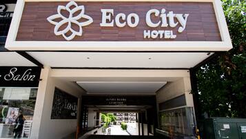 Der Eingang zum Eco City Hotel, mit einem Schild darüber und einem sichtbaren Salon-Schild links.