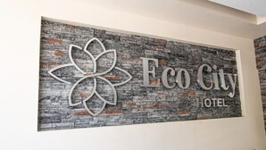 A wall with a logo and the text "Eco City Hotel".