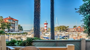A marina with boats, a lighthouse, and a building with a red roof. - 1017 Caravel Court at The Sea Pines Resort (Hilton Head Island)
