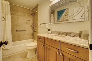 A bathroom with a bathtub, toilet, and a vanity with a sink and mirror. - 1023 Caravel Court at The Sea Pines Resort (Hilton Head Island)