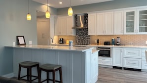A modern kitchen with a central island, white cabinets, and pendant lighting. - 1259 Harbour Town Club at The Sea Pines Resort (Hilton Head Island)