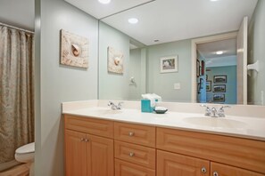 A bathroom with a double sink vanity, wooden cabinets, and a large mirror. - 1739 Bluff Villas at The Sea Pines Resort (Hilton Head Island)
