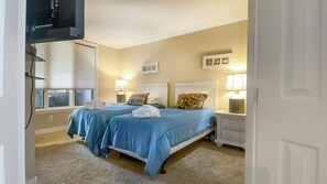 A hotel room with two beds, a TV mounted on the wall, and a window with blinds. - 1914 South Beach Club at The Sea Pines Resort (Hilton Head Island)