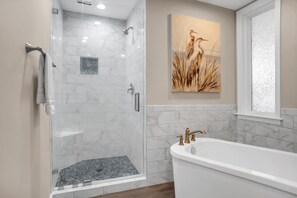 A modern bathroom with a glass-enclosed shower, a freestanding bathtub, and a wall-mounted sink. - 1924 South Beach Club at The Sea Pines Resort (Hilton Head Island)