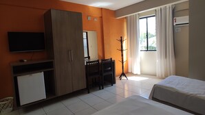 A hotel room with two beds, a television, a minibar, a desk, and a window with curtains. - Pousada Vila do Porto (Ipojuca)