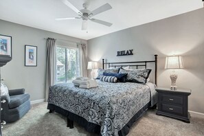 A bedroom with a bed, a ceiling fan, a nightstand with a lamp, and a wall-mounted sign that says "RELAX". - 2236 Heritage at The Sea Pines Resort (Hilton Head Island)