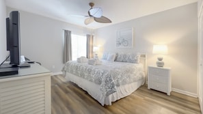 A hotel room with a bed, a desk with a computer, a ceiling fan, a window with curtains, and a wall-mounted artwork. - 2270 Heritage at The Sea Pines Resort (Hilton Head Island)
