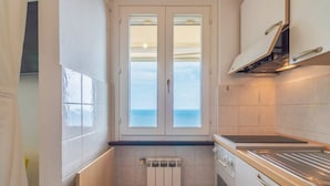 Cocina compacta con vistas a través de una puerta de cristal, estufa y radiador.
