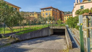 A paved area with a concrete structure, surrounded by buildings and greenery.