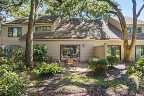 A two-story house with a patio area featuring a table and chairs. - 2302 Heritage Villas at The Sea Pines Resort (Hilton Head Island)