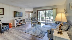 A living room with a sofa, a coffee table, a TV, and a lamp. - 2362 Racquet Club at The Sea Pines Resort (Hilton Head Island)
