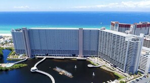 Un hotel gran amb nombrosos pisos, vistes al mar i un pati central amb fonts.