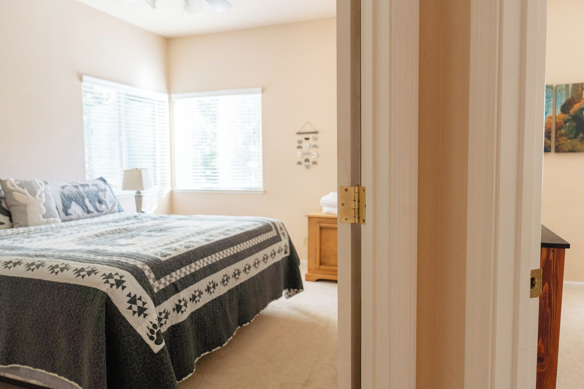 A bedroom with a bed, a nightstand, a window, and a door.