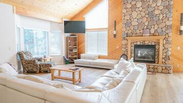 TV connectée, cheminée, table de tennis de table, livres