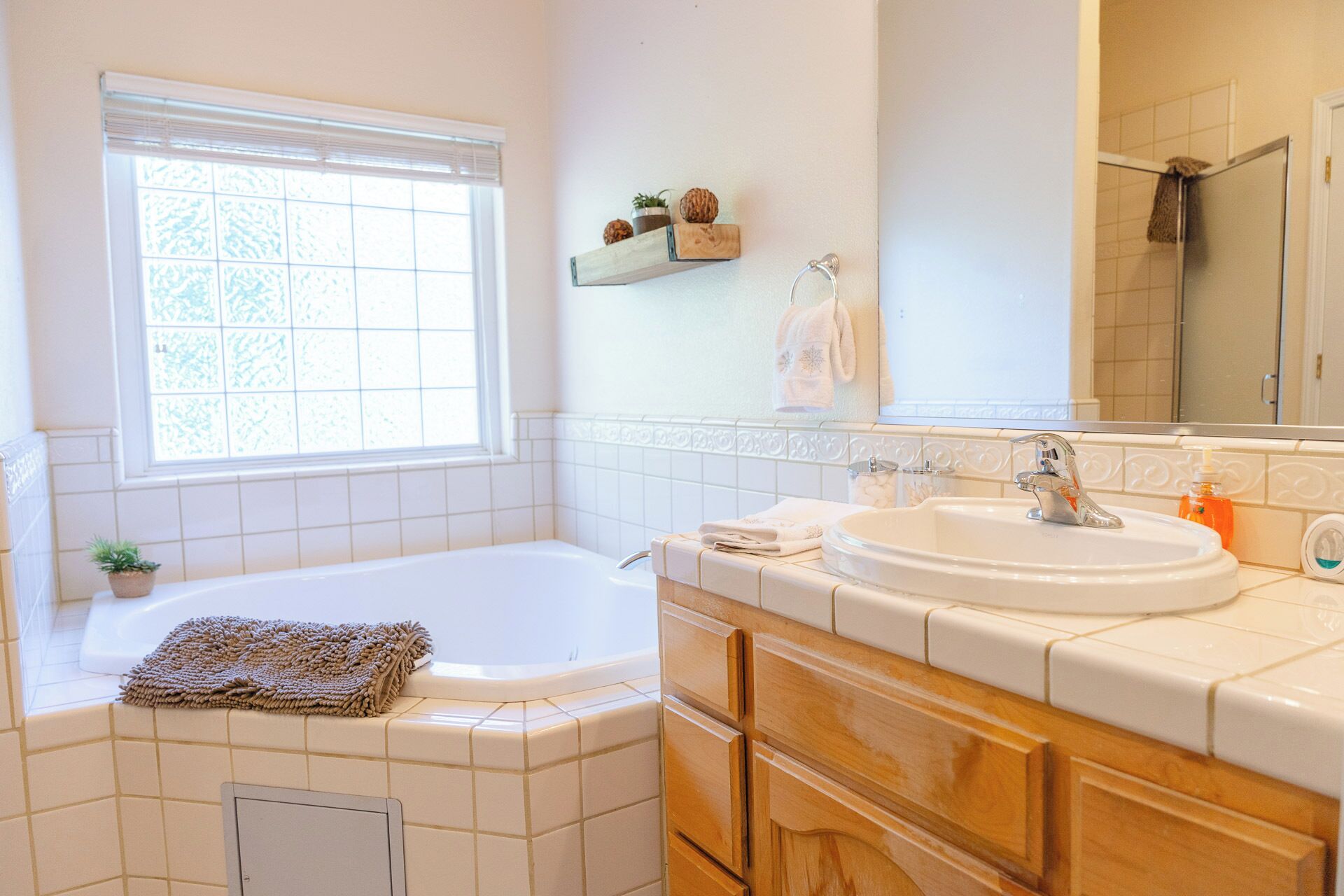 A bathroom with a bathtub, a sink, and a window.