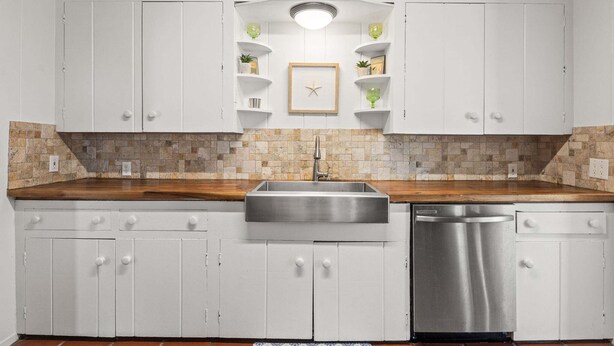 A kitchen with white cabinets, a stainless steel sink, and a dishwasher. - SP615  Pet Friendly, In Town, Near Beach (Port Aransas)