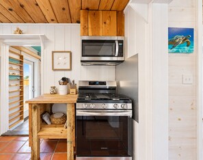 A compact kitchen with a microwave, oven, and stove. - SP615  Pet Friendly, In Town, Near Beach (Port Aransas)