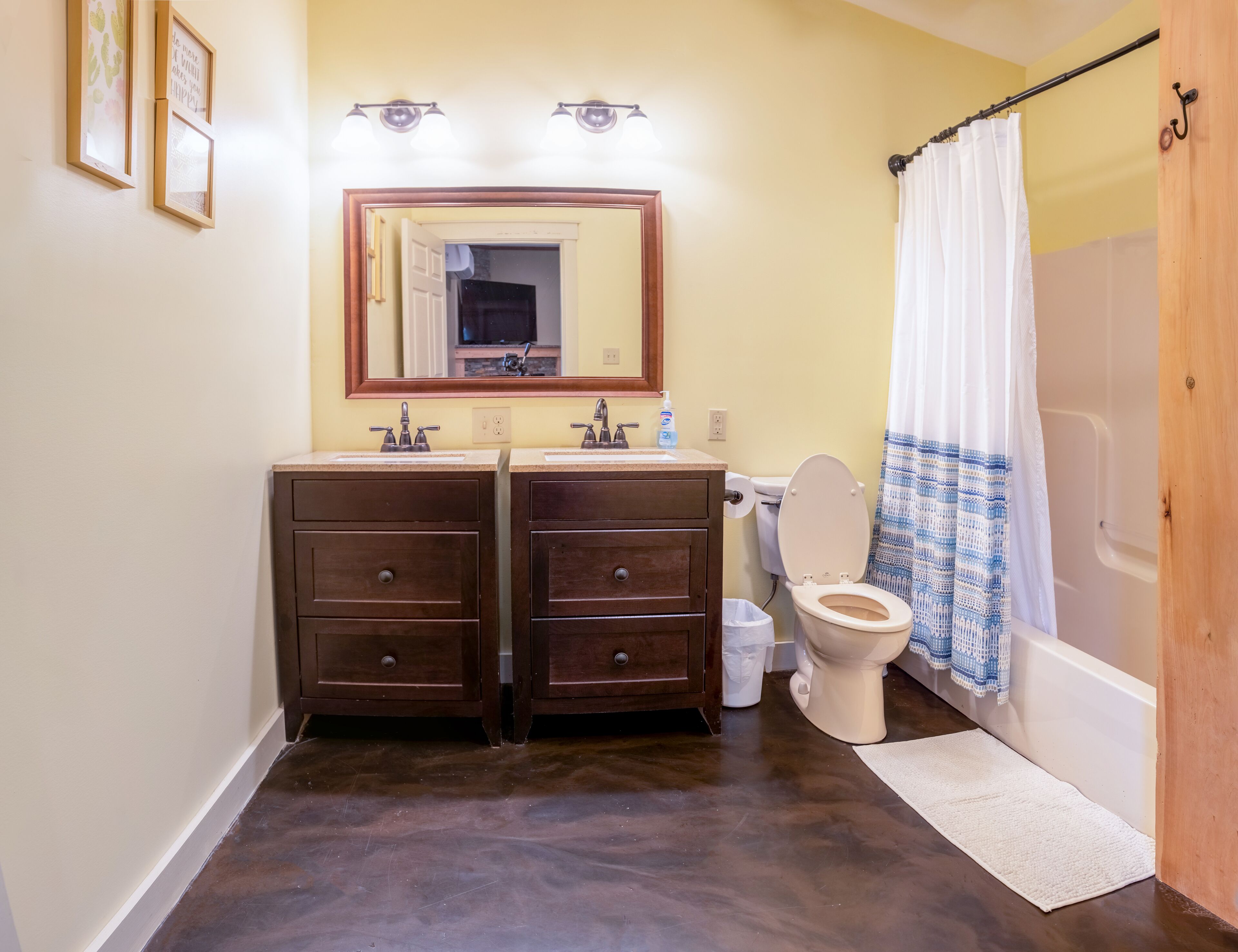 Een badkamer met een dubbele wastafel, toilet en douche.