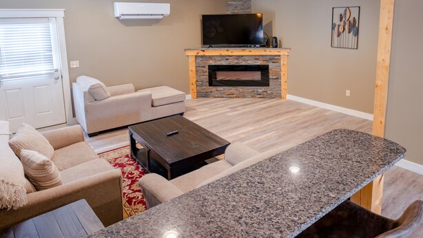 Una sala de estar moderna con un sofá, una mesa de centro, un televisor y una chimenea.