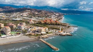 A coastal cityscape with a prominent lighthouse, beachfront, and mountainous backdrop. - Stunning private villa for 4 guests with WIFI, private pool, A/C, TV and terrace (Torrox)