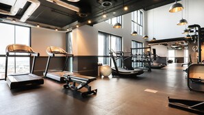 Una palestra con tapis roulant, ellittiche e attrezzi per pesi.