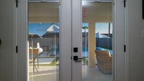 A set of white double doors with a security lock and a keyhole, leading to an outdoor area with a view of a house and a lawn. - 10 min to Old Town Scottsdale  (Scottsdale)