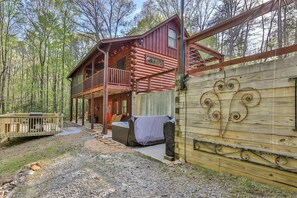 A cabin with a balcony, a covered porch, and a decorative wall. - Corkscrew Creek | Ellijay, GA (Talking Rock)