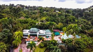 Ein Resort mit mehreren Gebäuden, umgeben von üppiger tropischer Vegetation.