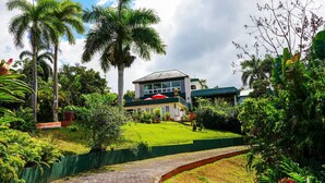 Ein Hotel mit Gründach, umgeben von üppiger Vegetation und Palmen.
