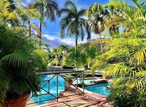 Een buitenzwembad, parasols bij het zwembad en ligstoelen