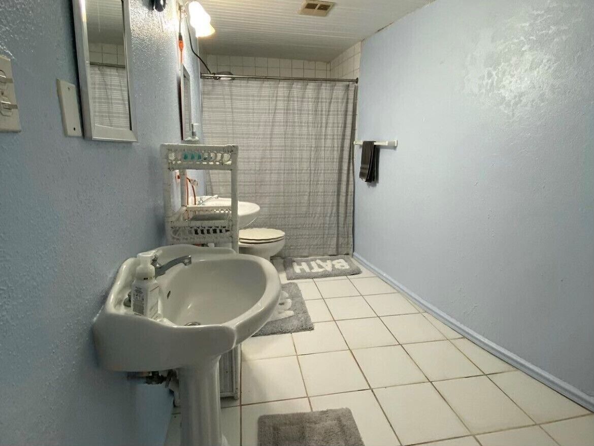 A bathroom with a sink, mirror, and toilet.