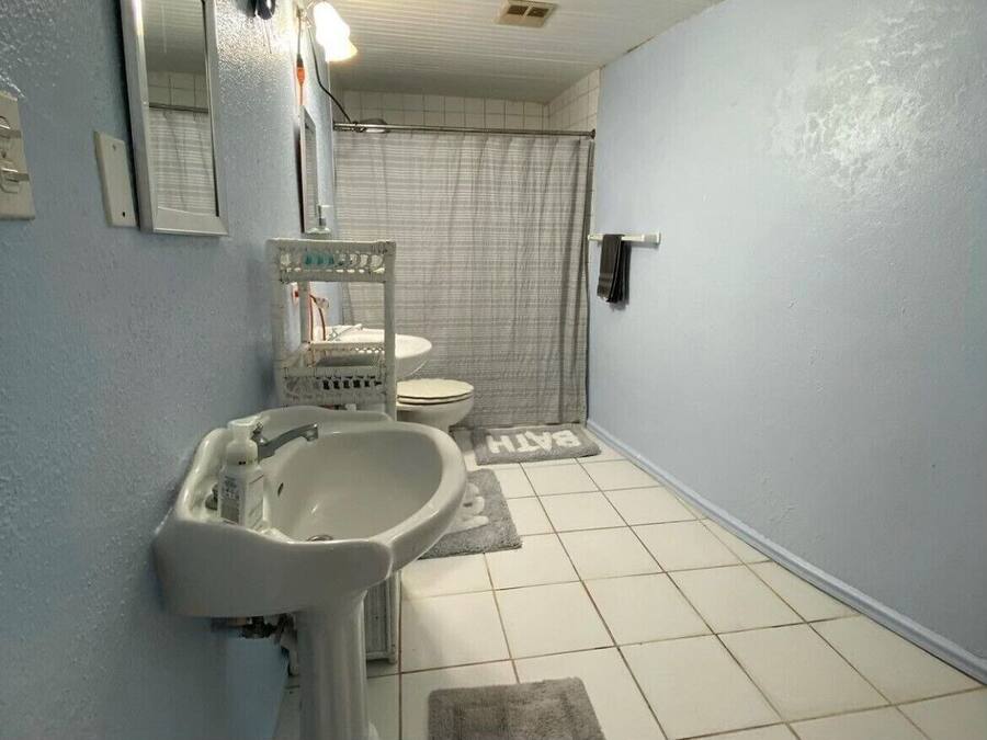 A bathroom with a sink, mirror, and toilet.