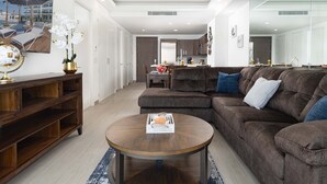 Un salon moderne avec un canapé d’angle marron, une table basse en bois et un grand miroir.