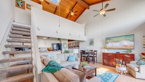 A spacious living area with a staircase, a dining area, and a kitchen.