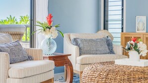En hyggelig stue med to sofaer, et sofabord og en dekorativ vase med blomster.