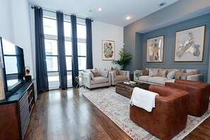 A modern living room with a sofa set, a coffee table, and a TV.
