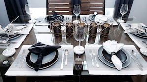 Une table à manger dressée pour quatre personnes, agrémentée d’un centre de table moderne aux motifs géométriques.