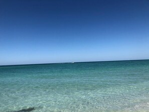 A clear view of the ocean with a boat in the distance.