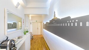 A hallway with a cityscape mural, a reception desk, and a wooden floor. - Riva City Rooms (Split)