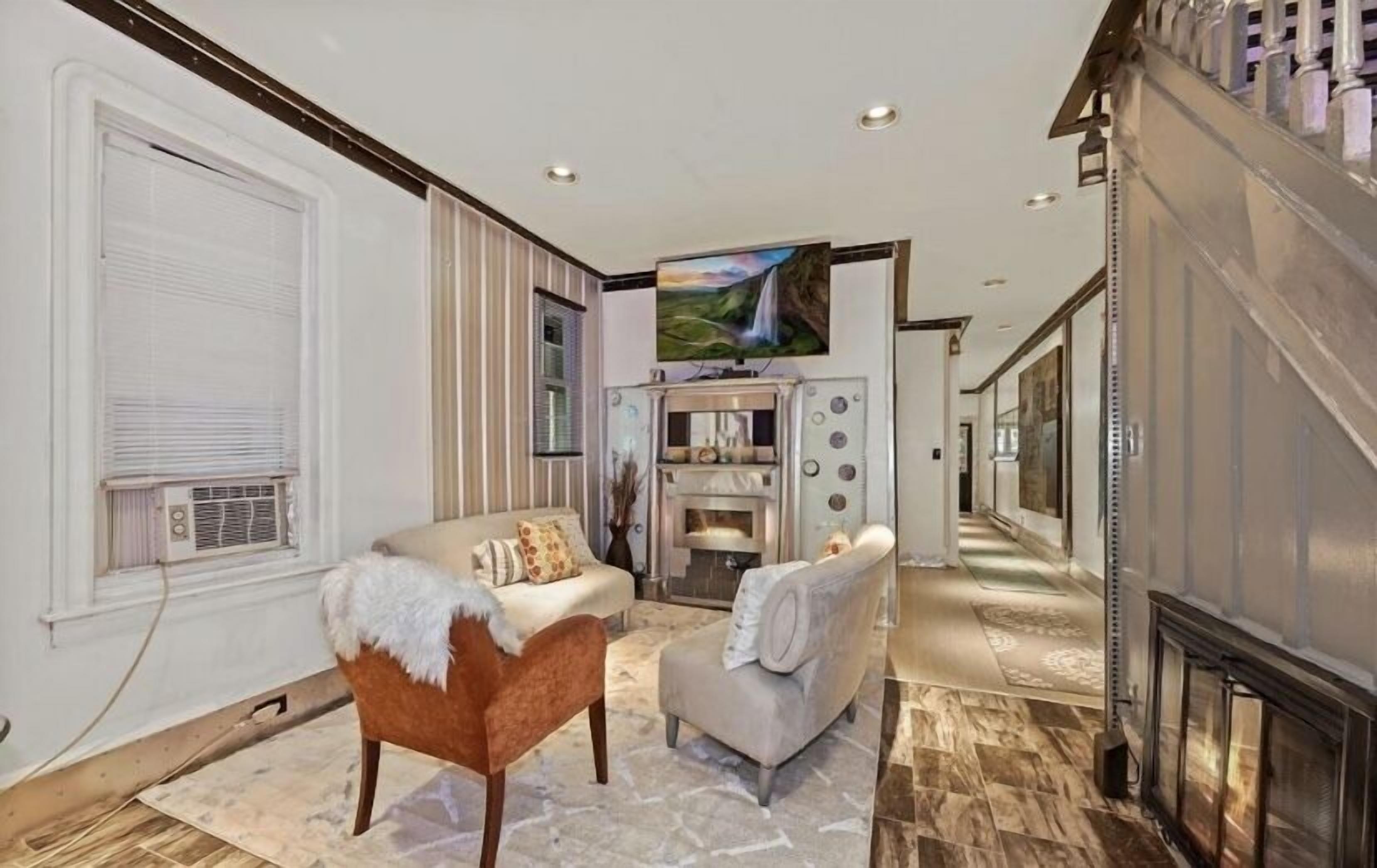 A spacious living room with a fireplace, a television, and a view of a waterfall.