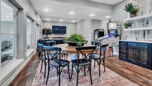 A modern kitchen with a central island, dark cabinetry, and a large window.