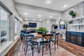 A modern kitchen with a central island, dark cabinetry, and a large window.