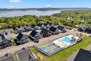 Un quartier résidentiel avec des maisons, une piscine et une vue sur un lac.