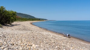 A pebbled beach with a clear view of the sea and a distant hill. - Villa Le Sorbe 12 in Caronia (Caronia)