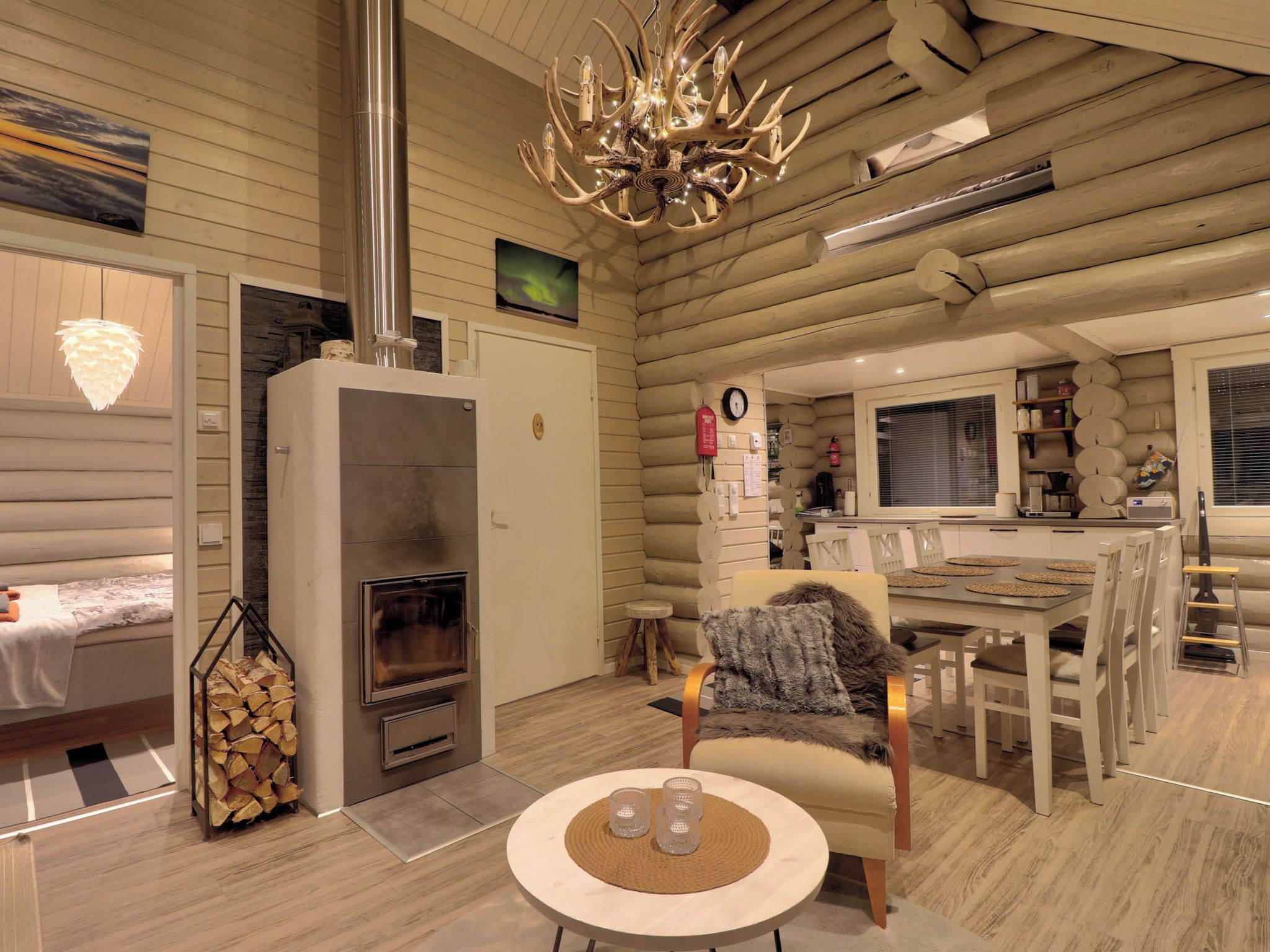 A log cabin interior with a fireplace, a dining area, and a cozy seating space.