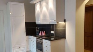 A compact kitchen with white cabinetry, a black countertop, and a built-in oven. - Lounge an der Kirche by Interhome (Hehlen)