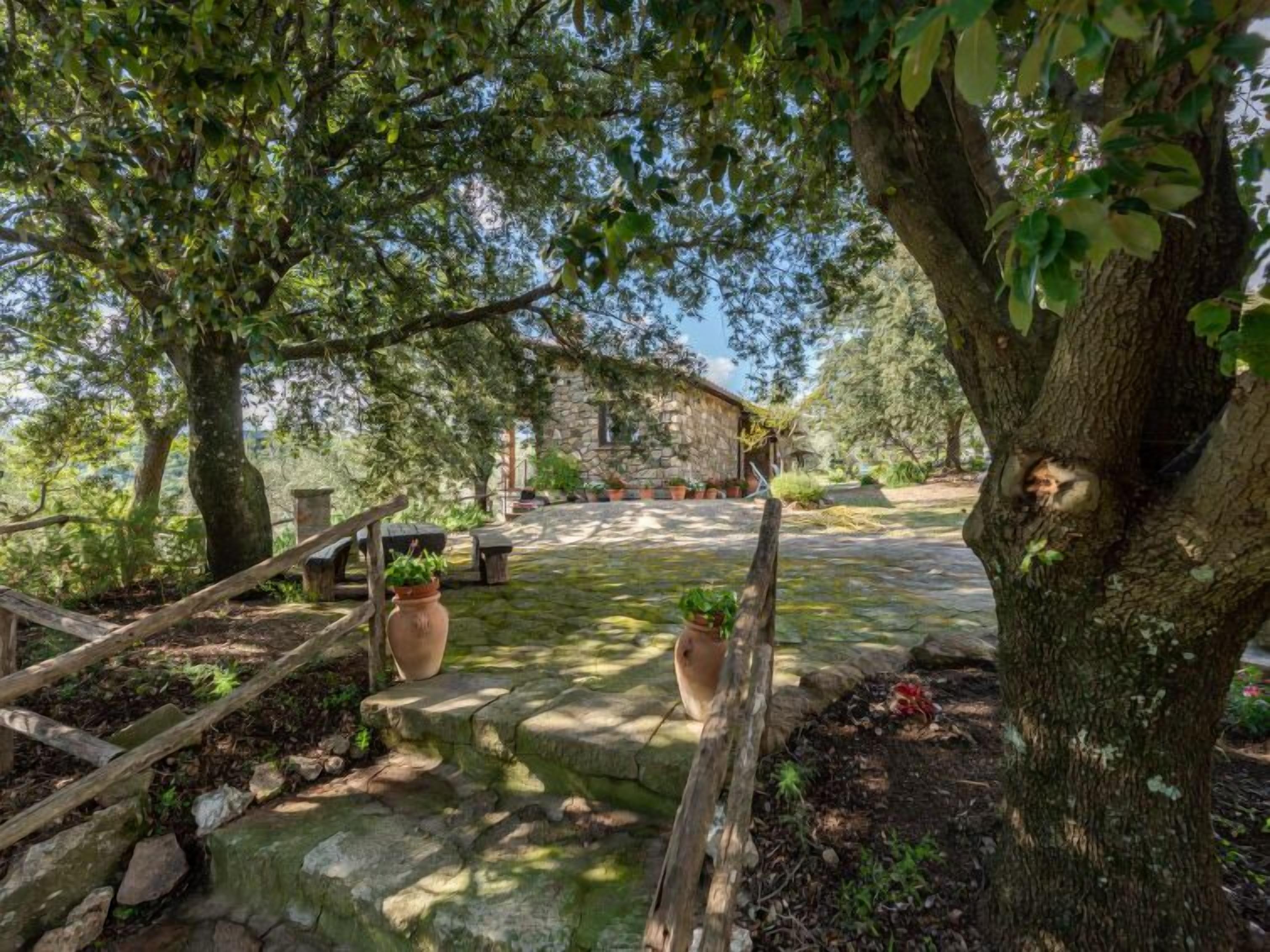 A stone building with a stone staircase leading to a wooden deck.