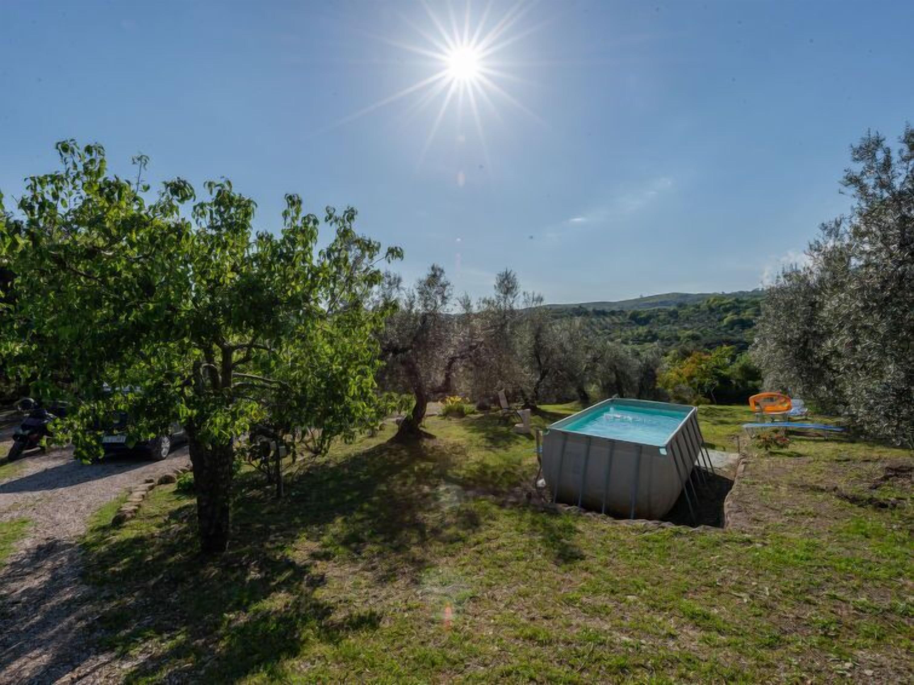 A pool area with a clear view of the surrounding landscape, including trees and hills.